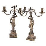 A pair of late 19thC silver plated candelabra, cast as a Roman God and Goddess, each supporting on