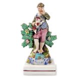 An early 19thC pearlware figure, manner of Walton, modelled as a standing boy, holding a puppy, with