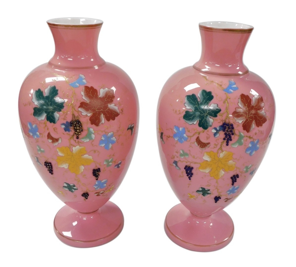 A pair of late 19thC pink opaline glass vases, of baluster form, painted with vines, and applied wit