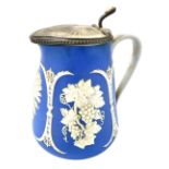 A late 19thC blue stoneware relief moulded jug, with hinged pewter lid and mount, sprig moulded with