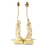 A pair of late 19thC French Parian table lamps, modelled as female water carriers, raised on painted