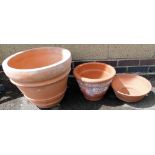 A terracotta plant pot, of cylindrical tapering form, 51cm wide, together with two further terracott