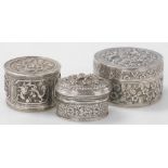 Two Indian white metal trinket boxes, each with embossed decoration, one of cylindrical form, decora