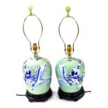 A pair of Chinese blue and white jar and cover table lamps, decorated with figures against a celadon