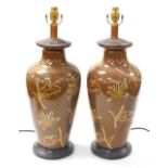 A pair of Chinese brown glazed table lamps, of shouldered tapering form, decorated with flowers and