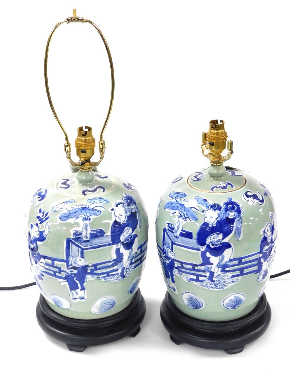 A pair of Chinese blue and white jar and cover table lamps, decorated with figures against a celadon