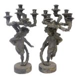 A pair of late 19thC Continental patinated metal five branch candelabra, modelled as putti, raised o