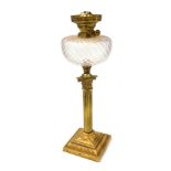 An early 20thC brass Corinthian column oil lamp, with a clear honeycomb glass reservoir, no chimney