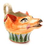 An early 19thC Staffordshire pearlware sauce boat, modelled as a fox's head, with a swan handle, 17c