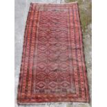 A Bokhara red ground rug, decorated in the central rectangular field with three rows of medallions,