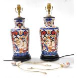 A pair of Chinese Imari porcelain table lamps, decorated with panels of birds and flowers, raised on