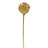 A Victorian tie pin, formed a white hard stone ball, with foliate overlay, yellow metal, 7.9g.
