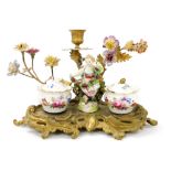A 19thC Continental porcelain and brass desk stand, the stand surmounted by a figure of a girl holdi