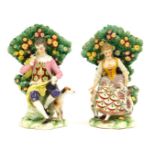 A pair of Continental Derby style porcelain figure groups, of lady and gentleman seated on perch wit