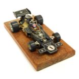 A Corgi John Player Special F1 diecast vehicle, on wooden plinth, 31cm x 15cm.