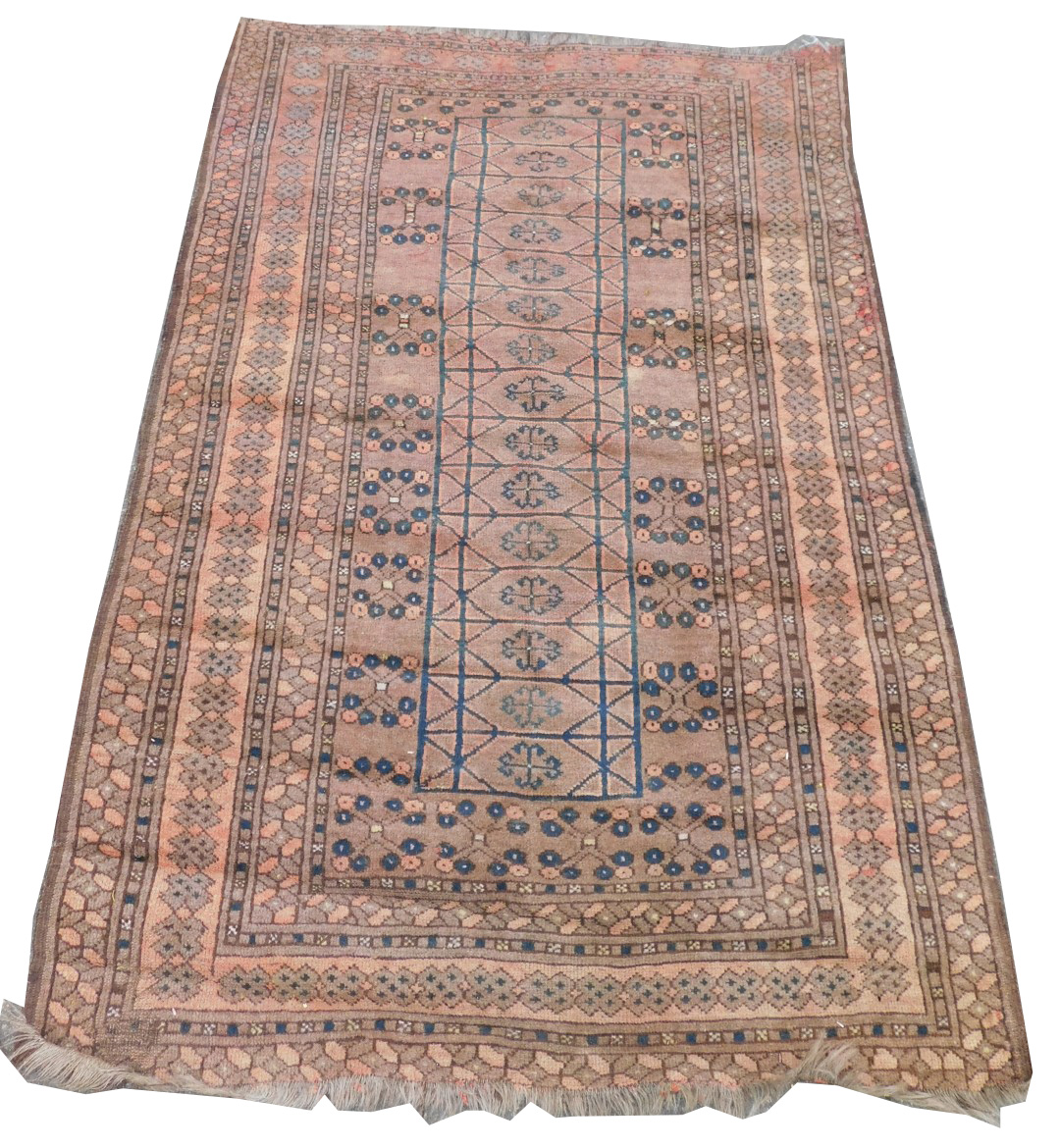 An Afghan red ground rug, the central ground decorated with floral motifs within rectangular compart