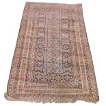 An Afghan red ground rug, the central ground decorated with floral motifs within rectangular compart