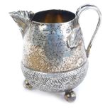 A late Victorian silver acorn cream jug, of oak leaf spout and raised on three ball feet, makers mar