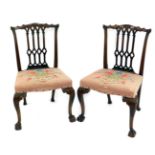 A pair of Gothic Chippendale design chairs, with carved backs, serpentine seats, and cabriole legs w