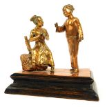 An Oriental copper figure group, of two females in mid conversation, perched on a rock, on a stepped