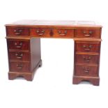 A reproduction mahogany twin pedestal desk, with a gilt tooled red leather top, above one long and e