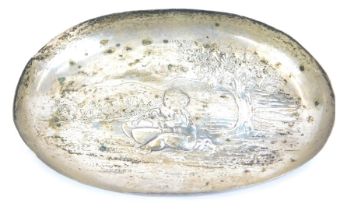 A Victorian oval pin tray, with repousse decoration of a putti drumming in a landscape setting, make