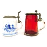 Two early 20thC tankards, comprising a Bohemian ruby glass example, the lid decorated with horse and