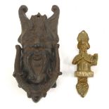 Two door knockers, comprising a reproduction cast Zeuss head door knocker, 17cm high, and a brass kn