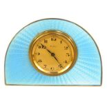 An Art Deco white metal travelling clock, the arched form set with blue enamel, the case unmarked, w