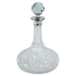 A cut glass decanter and stopper with silver collar , with squat base, 28cm high.