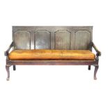 A George III oak settle, with a quadruple panelled back and solid seat, with later tan leather cushi