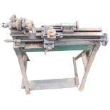 A mechanical lathe, on metal and wooden trestle base, 106cm high, 82cm wide.