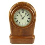 A 20thC elm cased mantel clock, with an arched top, with a circular cream painted metal dial with Ro