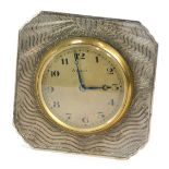 A white metal framed strut clock, of square form with waved sun design and brass central eight day c
