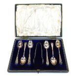 A cased set of Edward VII silver teaspoons and sugar tongs, fiddle pattern with etched floral engrav