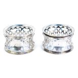 A pair of late Victorian silver napkin rings, of pierced circular waisted form, with blank cartouche