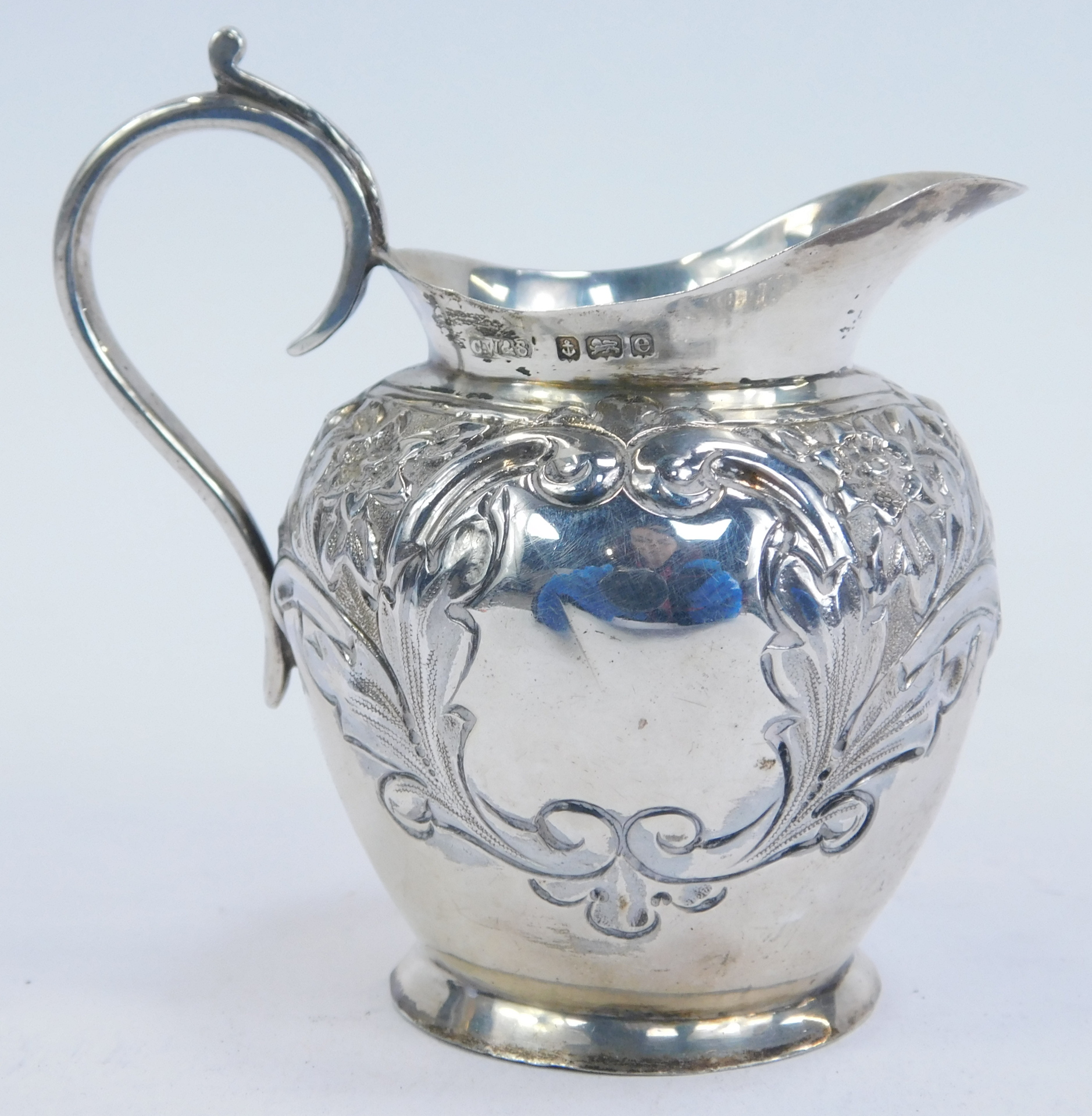 An Edwardian silver cream jug, of tapered ovoid form, with repousse decoration of flowering foliates - Image 3 of 3
