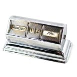 A mid century chrome case desk calendar, with spin dial for Day, Date and Month, on rectangular base