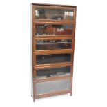 A Globe Wernicke style oak six section bookcase, with glazed up and over doors, raised on square fee