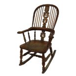 A Victorian oak and elm Windsor rocking chair, with a vase shaped carved splat, solid saddle seat, r