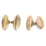 A pair of 9ct gold oval cuff links, each partially engraved with foliate scroll decoration, 3.06g.