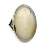 A silver and moonstone effect dress ring, with carved cameo depicting maiden leaning on anchor, the