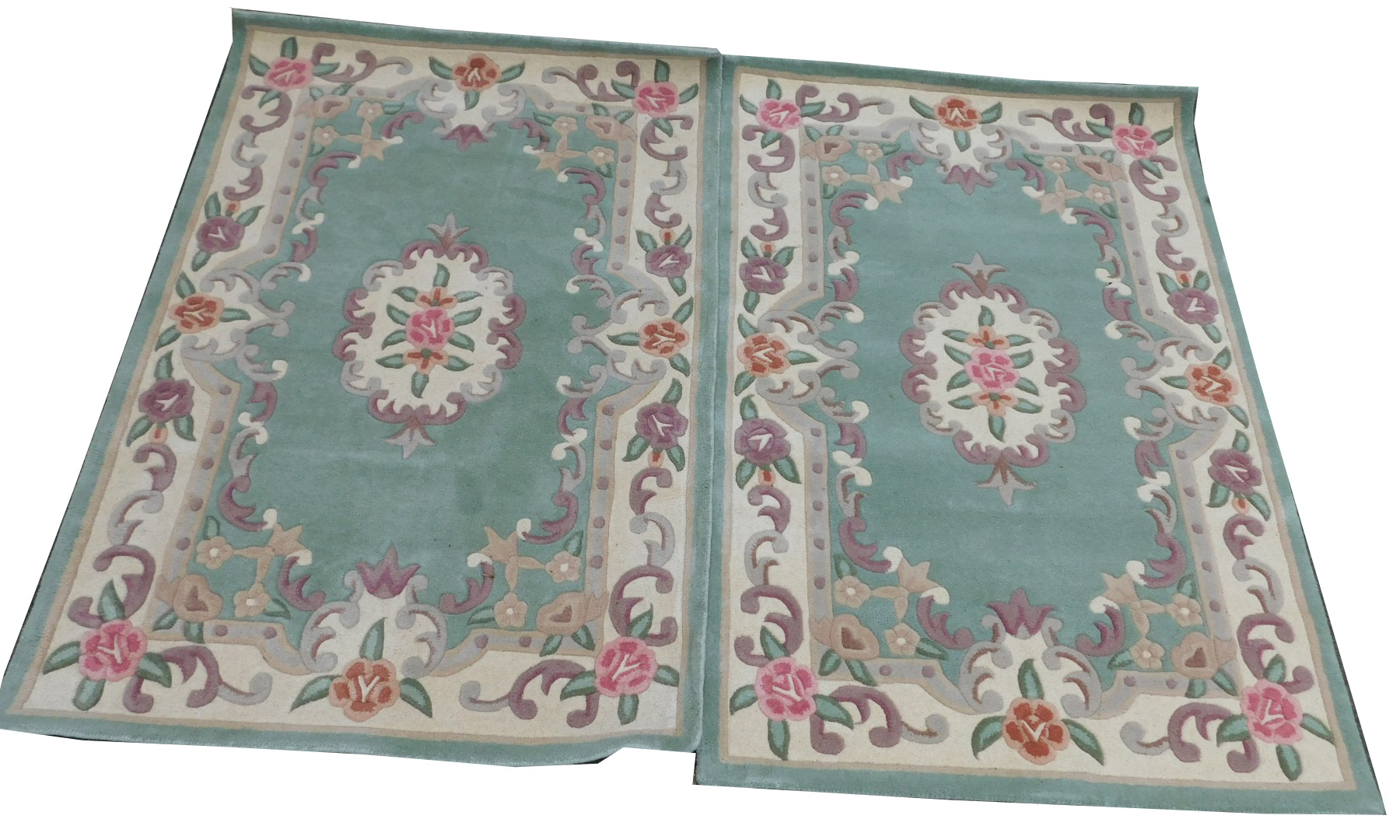 A pair of Chinese sea green ground rugs, with floral decoration, each 178cm x 118cm.