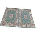 A pair of Chinese sea green ground rugs, with floral decoration, each 178cm x 118cm.