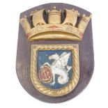 A gilt painted metal ships plaque, the shield depicting a hippocampus with an oval shield with an an