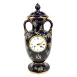 A French Severe style porcelain mantel clock, formed as a vase and cover, on navy blue ground, ename