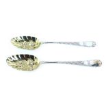A pair of Victorian silver berry spoons, each fiddle pattern top, with heavily engraved handle and b