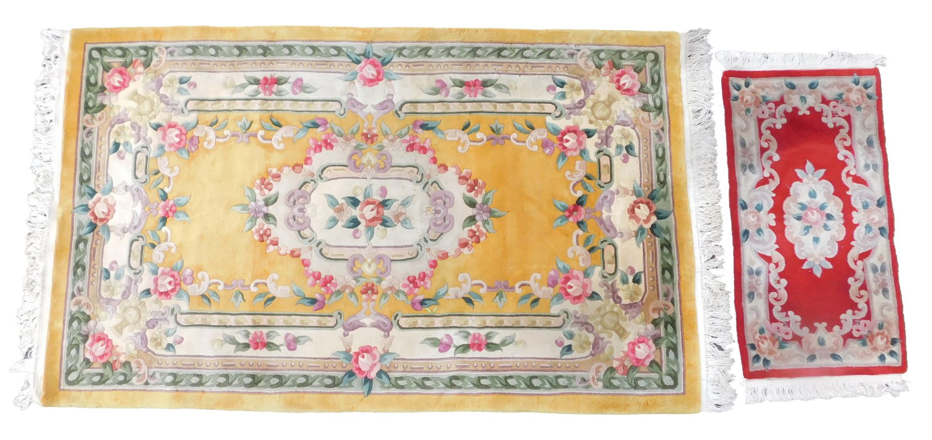 A Chinese wool cut rug, yellow ground with decorated leaf scrolls, etc, with tassel borders, togethe
