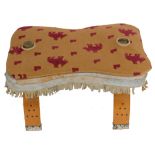 A camel stool, with a leather cushion seat, 59cm wide. The upholstery in this lot does not comply w