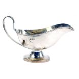 A George V silver sauce boat, of plain design with stylised rat tail handle, and raised on a tapered